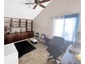Bright office space with vaulted ceilings, built-in shelving, and a large window for natural light at 3782 S Genoa Cir # A, Aurora, CO 80013