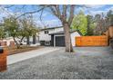 Driveway next to a home showcasing gray gravel, a wooden fence, and an attached garage at 11172 W Exposition Dr, Denver, CO 80226