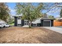 Charming split-level home showcasing a black and white exterior, attached garage, and front yard at 11172 W Exposition Dr, Denver, CO 80226