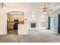 Open-concept living room with fireplace, balcony access, and view into the kitchen at 12711 Colorado Blvd # 607F, Thornton, CO 80241
