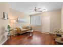 Cozy living area with wood floors, a ceiling fan, and a comfortable sofa illuminated by a bright window at 2662 S Cathay Way # 112, Aurora, CO 80013
