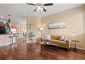 Inviting living room featuring rich wood floors, a ceiling fan, and a comfortable seating area with natural light at 2662 S Cathay Way # 112, Aurora, CO 80013