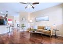 Bright living room with hardwood floors, a tan sofa, and views into the kitchen at 2662 S Cathay Way # 112, Aurora, CO 80013