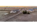 Expansive aerial view of the property featuring several buildings, sheds, and a gravel driveway in a rural landscape at 35055 E Mississippi Ave, Watkins, CO 80137