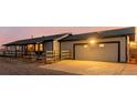 Exterior shot of attached garage and the home's side, accented by wood fence and evening light at 35055 E Mississippi Ave, Watkins, CO 80137