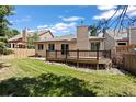 Charming backyard view featuring a well-kept lawn and a wooden deck perfect for outdoor living at 14139 W Warren Dr, Lakewood, CO 80228
