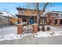 Charming brick home with a fenced front yard and walkway, snow on the ground at 1131 S York St, Denver, CO 80210