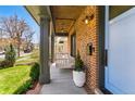 Inviting front porch with swing, brick facade, and a beautifully landscaped yard and front door at 1131 S York St, Denver, CO 80210