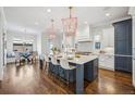 Bright, spacious kitchen with a large center island, modern appliances, pendant lighting, and hardwood floors at 1131 S York St, Denver, CO 80210