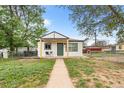 Charming home with a sidewalk leading to the front entrance, a covered porch, and a fenced yard at 6980 Niagara St, Commerce City, CO 80022
