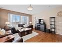 Inviting living room with rich hardwood floors, plentiful natural light, and stylish, comfortable furniture at 9382 Pike Way, Arvada, CO 80007