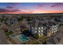 An aerial view of the condo complex, showcasing the community pool and surrounding neighborhood at sunset at 15700 E Jamison Dr # 6-101, Englewood, CO 80112