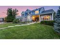 Beautiful two-story blue home with lush green lawn and inviting front porch at 1496 Meyerwood Cir, Highlands Ranch, CO 80129