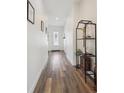 A bright hallway with wood floors, white walls, and stylish decor leading to the front door at 4422 Mt Shavano St, Brighton, CO 80601
