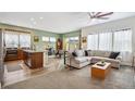 Open-concept living room with a modern kitchen, cozy seating area, and abundant natural light at 4422 Mt Shavano St, Brighton, CO 80601