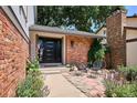 Inviting front entrance with brick facade, modern seating, and vibrant flowers, and well-manicured landscaping at 12651 E Bates Cir, Aurora, CO 80014