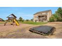 Spacious backyard featuring a playset, trampoline, and a well-maintained lawn at 14825 Almstead St, Hudson, CO 80642