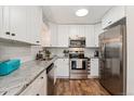 Modern kitchen with stainless steel appliances, granite countertops, and white cabinets at 7020 E Girard Ave # 209, Denver, CO 80224
