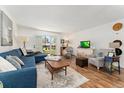 Bright living room with a sliding door to the patio, hardwood floors, and comfortable furniture at 7020 E Girard Ave # 209, Denver, CO 80224