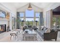 Bright living room with fireplace, vaulted ceilings, large windows, and mountain views at 26806 Evergreen Springs Rd, Evergreen, CO 80439