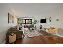 Bright living room with hardwood floors, neutral decor, balcony access, and comfortable seating arrangements at 1050 N Corona St # 202, Denver, CO 80218