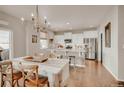 Open dining room featuring hardwood floors, chandelier, and a view into the kitchen at 20727 Park Hollow Dr, Parker, CO 80138