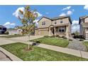 Charming two-story home boasts manicured landscaping, stone accents, and inviting front porch seating at 20727 Park Hollow Dr, Parker, CO 80138