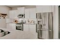 Modern kitchen with stainless steel appliances, white cabinets, and granite countertops at 20727 Park Hollow Dr, Parker, CO 80138