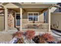 Inviting front porch features decorative stonework, a cozy seating area, and a welcoming entrance at 20727 Park Hollow Dr, Parker, CO 80138