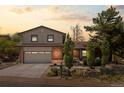 Charming two-story home featuring a brick facade, well-manicured landscaping, and an attached two-car garage at 14533 W 3Rd Ave, Golden, CO 80401