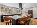 Modern kitchen with a large island, stylish barstools, stainless steel appliances, and unique backsplash at 14533 W 3Rd Ave, Golden, CO 80401