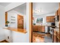 Bright kitchen with wood cabinets, stainless steel appliances, and view of a breakfast bar area at 10983 W Exposition Pl, Lakewood, CO 80226