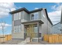Charming two-story home boasts stylish gray exterior, covered porch, and neat landscaping at 21091 E 63Rd Dr, Aurora, CO 80019