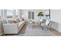 Bright living room featuring neutral tones, stylish furniture, and large windows at 21091 E 63Rd Dr, Aurora, CO 80019