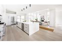 Bright, open-concept kitchen featuring a large center island and stainless steel appliances at 3022 Fenton St, Wheat Ridge, CO 80214