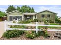 This home boasts lovely curb appeal with a well-maintained lawn and inviting white picket fence at 6811 S Clermont Dr, Centennial, CO 80122