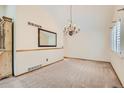 Spacious dining room featuring modern chandelier, neutral paint, and large windows at 10365 E Weaver Cir, Englewood, CO 80111