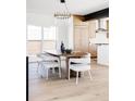 Modern dining area with stylish lighting, neutral tones and view to kitchen at 1880 S Adams St, Denver, CO 80210