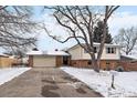 Charming exterior showcasing a well-maintained lawn, driveway, and a two-car garage, all in a serene neighborhood setting at 6048 Xenon St, Arvada, CO 80004