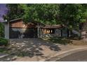 Charming single-story home with a brick facade, mature trees, and a two-car garage at 10051 E Walsh Pl, Denver, CO 80247