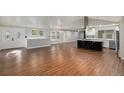 Spacious living room featuring hardwood floors, natural light, and an open layout to the kitchen at 10051 E Walsh Pl, Denver, CO 80247