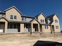 View of newly built townhomes with modern designs and neutral color schemes, ready for landscaping at 17145 W 91St Ln, Arvada, CO 80007
