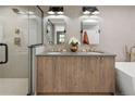 Modern bathroom with double vanity, wood cabinets, a glass-enclosed shower, and gold fixtures at 2395 N Emerson St, Denver, CO 80205