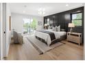 Calm, bright main bedroom with a modern accent wall, balcony, and neutral furnishings at 2395 N Emerson St, Denver, CO 80205