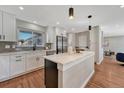 Modern kitchen featuring white cabinets, a center island with a white countertop, and stainless steel appliances at 3802 E Costilla Ave, Centennial, CO 80122