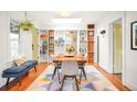 Stylish dining room with custom shelves, brick detail, and seating for four, plus hardwood floors at 1232 Wabash St, Denver, CO 80220