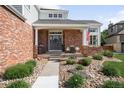 Inviting front porch with brick facade, flower boxes, a seating area, and a stone walkway at 16658 Black Oak Ct, Parker, CO 80134