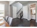 Dining room with a gray wall, staircase, and entry to a half bath, accentuated by dark hardwood floors at 578 Sage Grouse Cir, Castle Rock, CO 80109