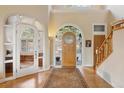 Bright foyer with an impressive front door, staircase, and an arched doorway leading into an office at 30082 Troutdale Ridge Rd, Evergreen, CO 80439