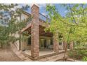 The back of the house showing a patio with brick pillars and a deck above at 6085 Nile Cir, Golden, CO 80403